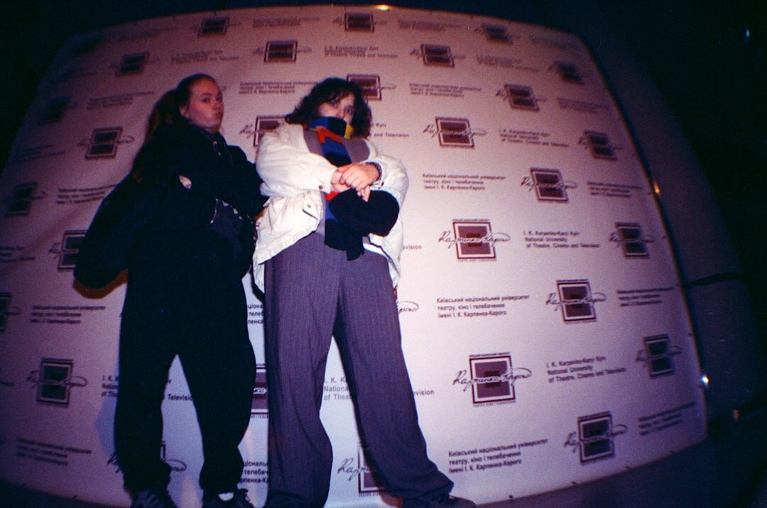 Celebrities walking a red carpet at a film premiere with photographers